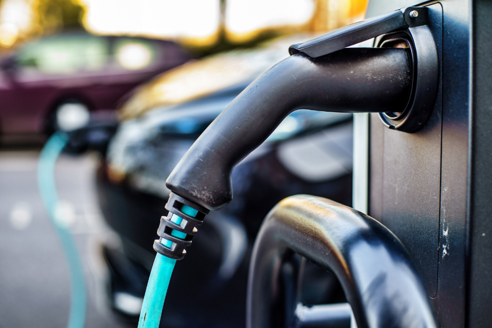 Carro elétrico sendo recarregado com energia produzida por painéis solares